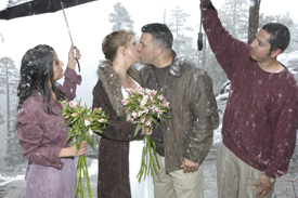 Snowflakes fall on the newlyweds and wedding party