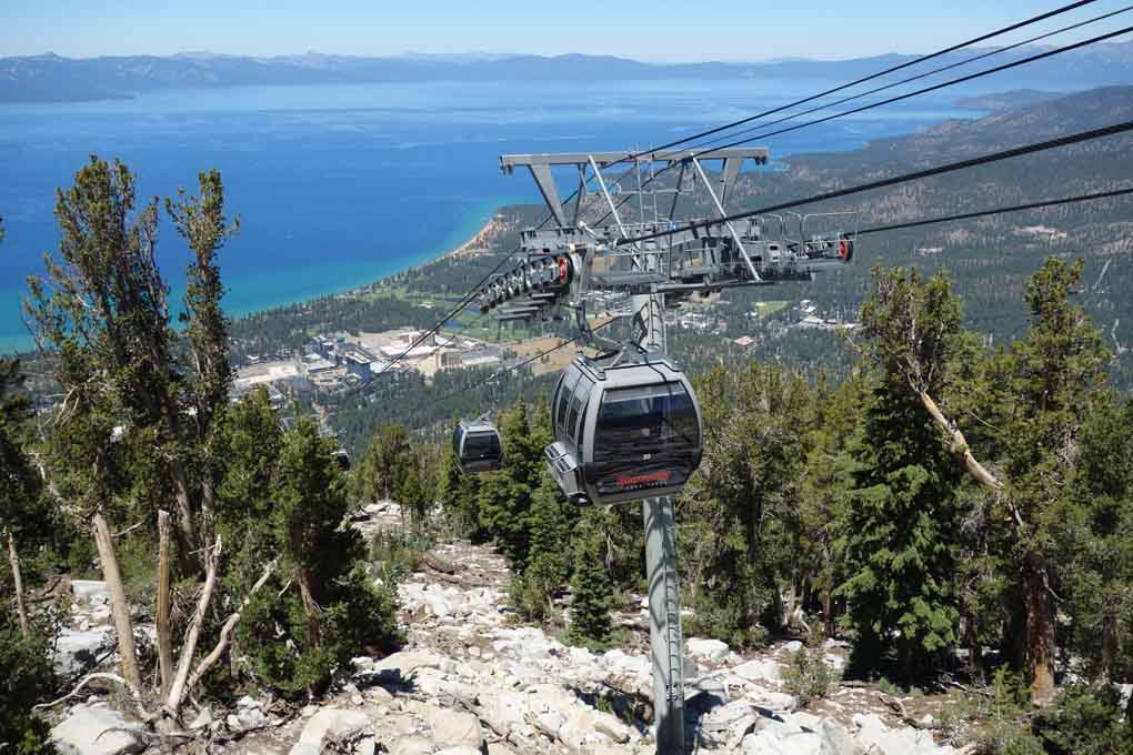 Heavenly Mountain gondola car ascending up the mountainside with Lake Tahoe in the background.