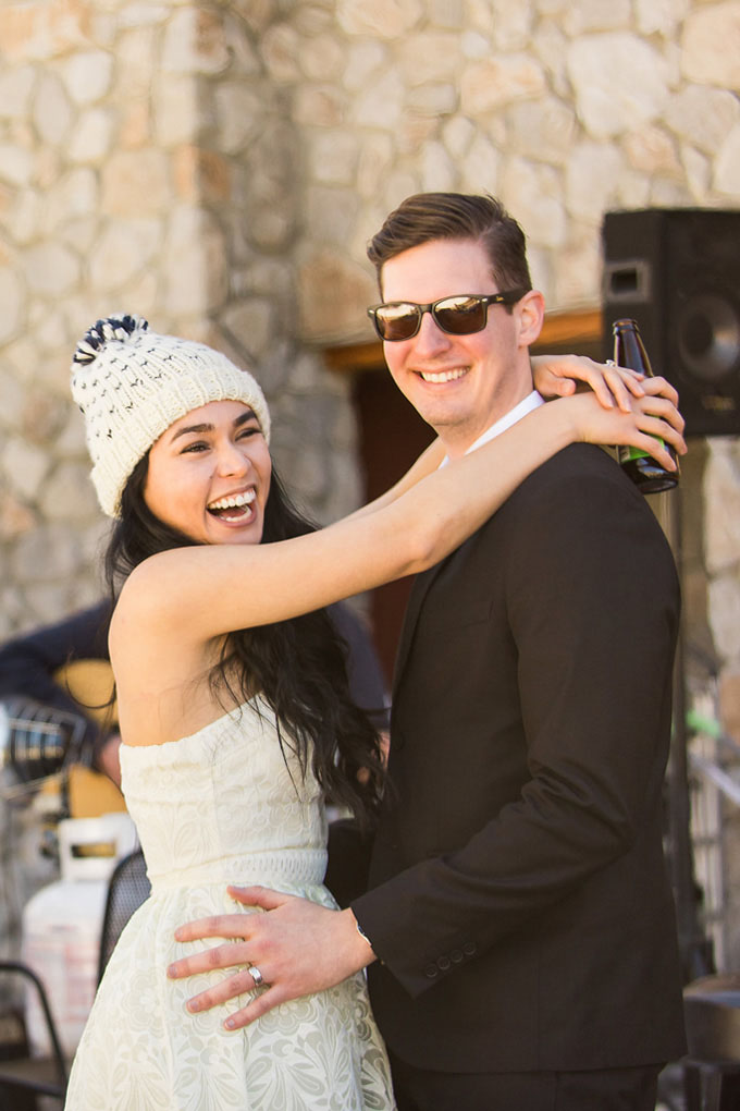 The bride and groom smile happily as they hold each other.