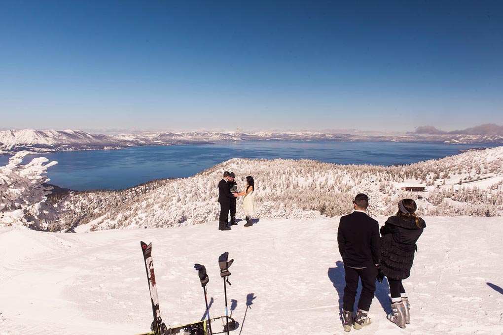 Bride and groom hold hands on the snowy mountain during their service.