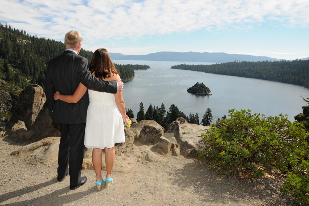 Couple admires the view while standing near the edge of the bluff overlooking Emerald Bay.