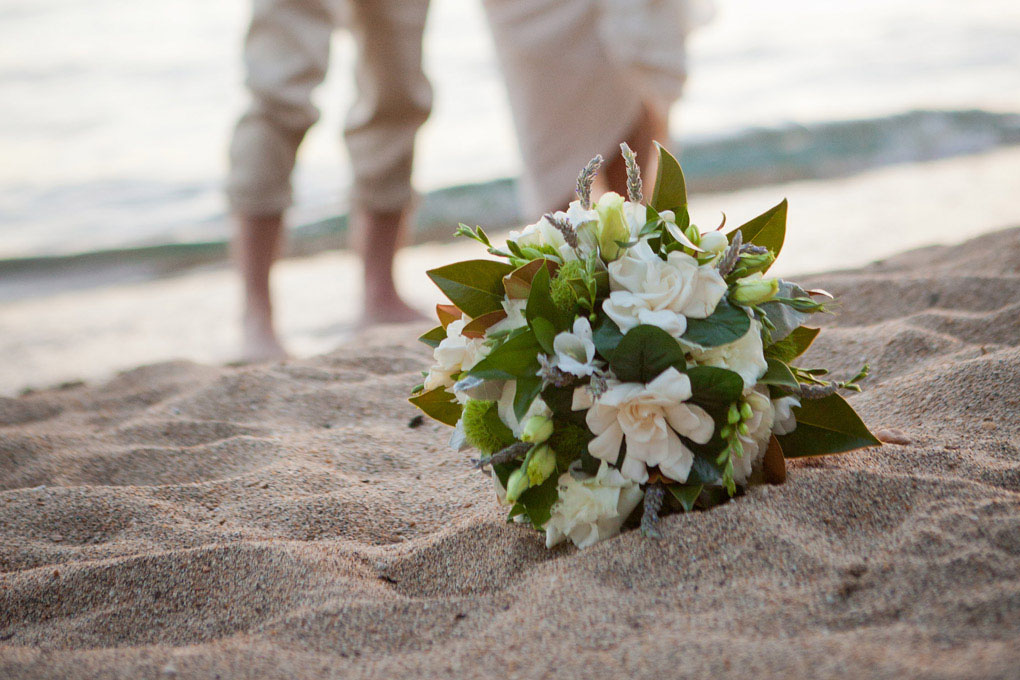 Rose bouquet resting on the beach sand.