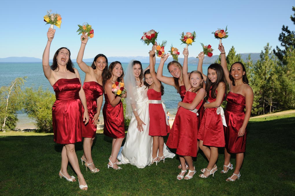 Bridesmaids are holding their bouquets up and over their heads.