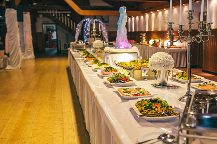 Long decorated table lined with an assortment of food.