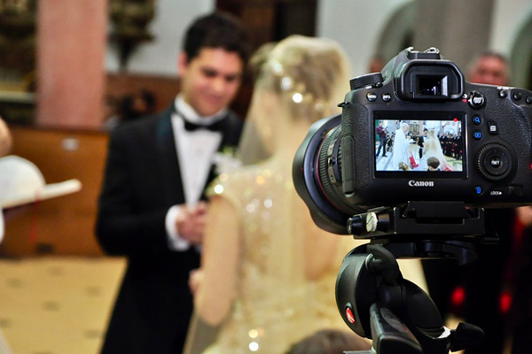 Bride and groom being filmed during their event.