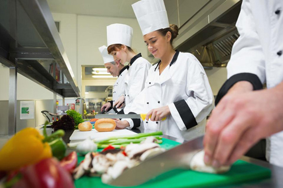 Assembly line of cooks preparing a meal.