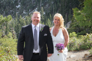 Newly married pose in front of a forested area.
