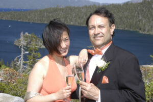 Formally dressed newlyweds have champagne toast at Emerald Bay.