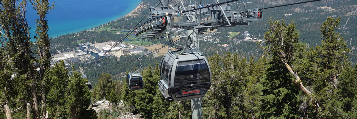 Gondola car ascending Heavenly Mountain with aerial view of South Lake Tahoe.