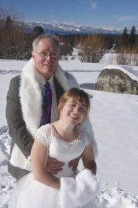 Groom holds up his bride who is sinking in the snow.