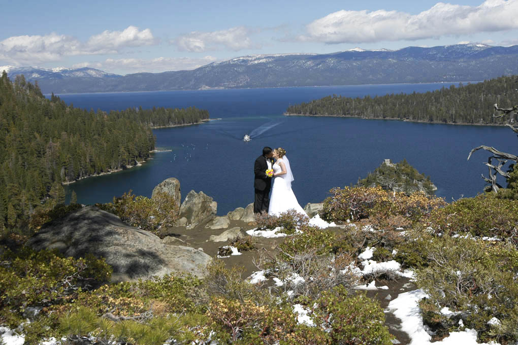 Newlyweds have their first kiss on the bluff of Emerald Bay.