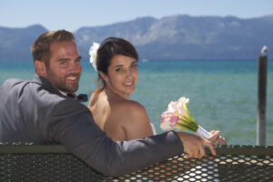 The pair are sitting on a bench looking back over their shoulders.