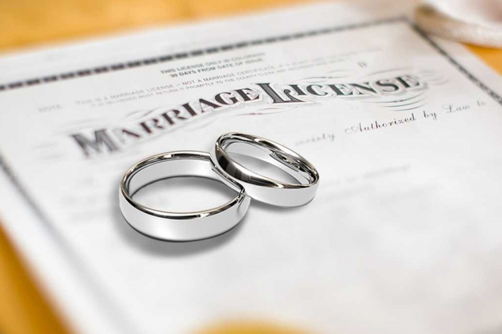 Wedding rings sitting on top of a marriage license document.