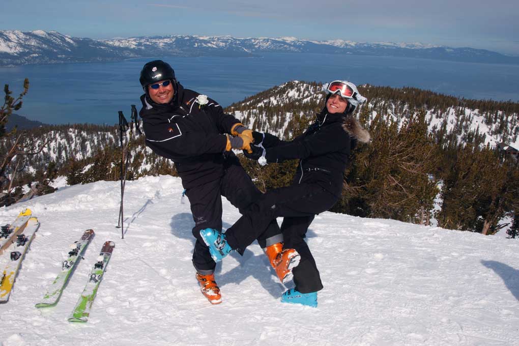 Two skiers having fun on the snow with their skis off.