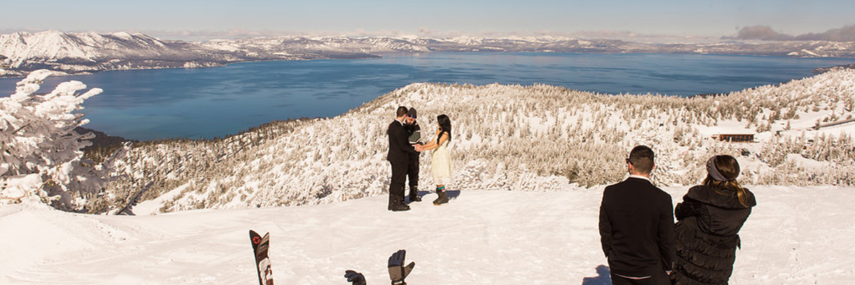 Mountaintop wedding with two onlooking spectators with Lake Tahoe in the background.