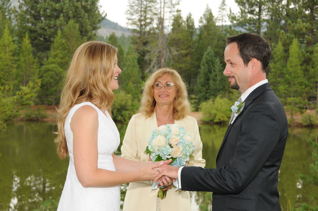 Marriage participants holding hands while reciting their vows.