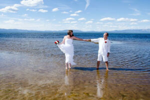 Bride and her groom dance around in the lake in their casual wedding attire.
