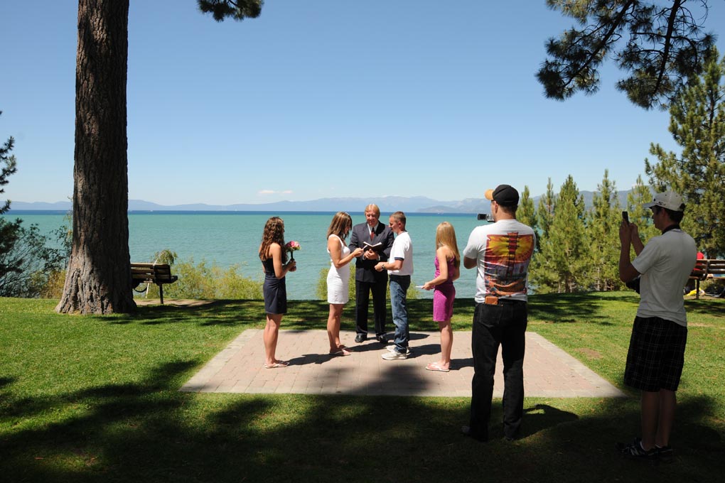 Pastor recites a passage from the bible as the bridal party and guests listen.
