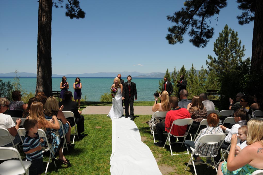 Newly married walking down the aisle as the beach wedding recessional commences.