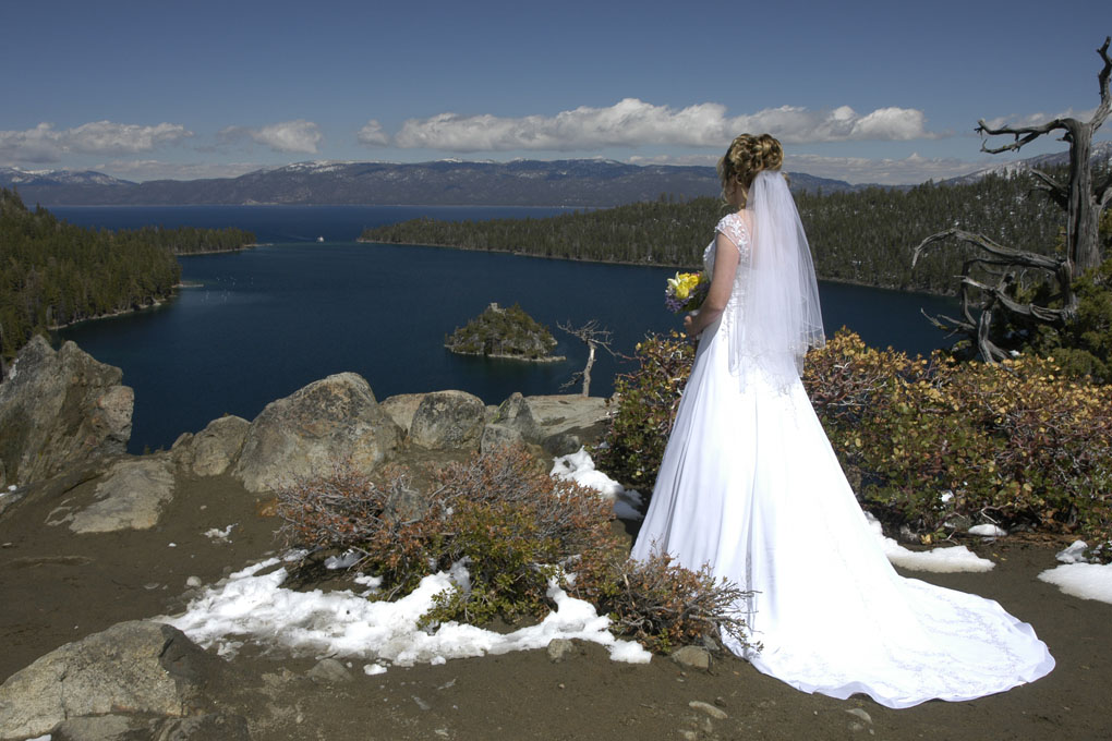 Bride in her beautiful wedding dress looking outward toward Emerald Bay.