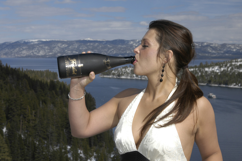 Beautiful bride taking a swig out of the champagne bottle.