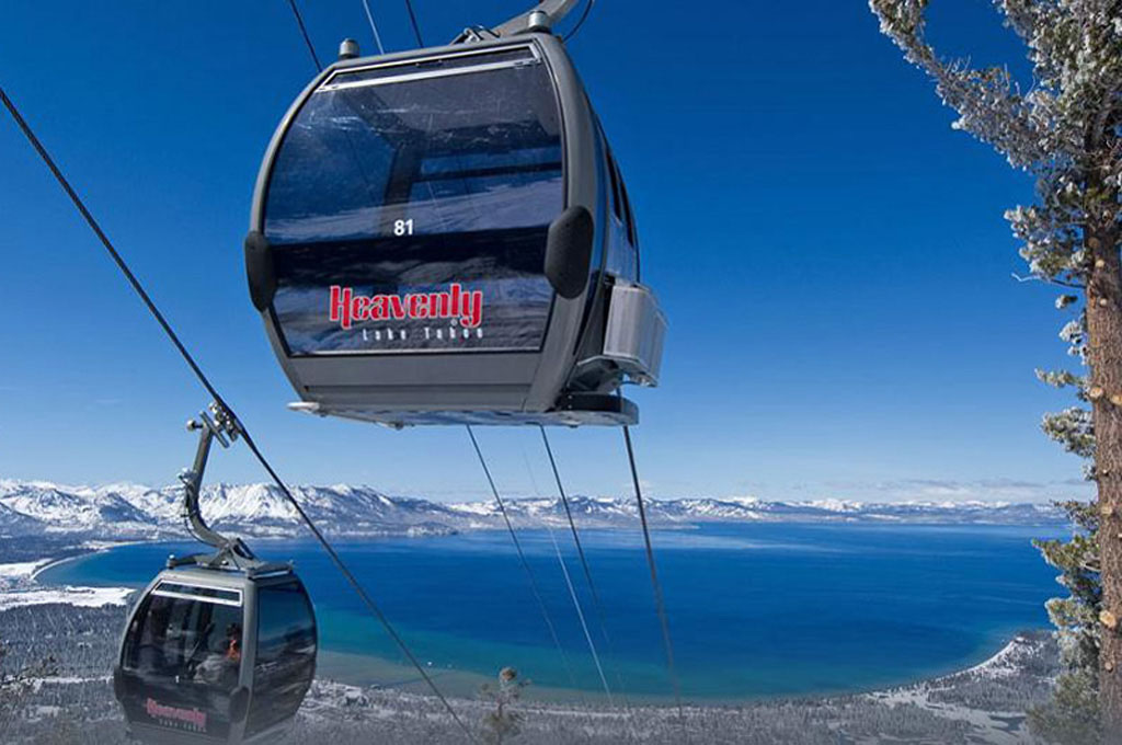 Ascending and descending gondola cars with lake background.