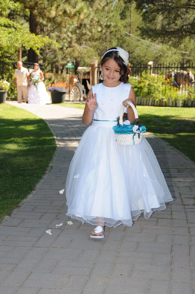 Flower girl tossing her rose petals as she walks down the aisle.