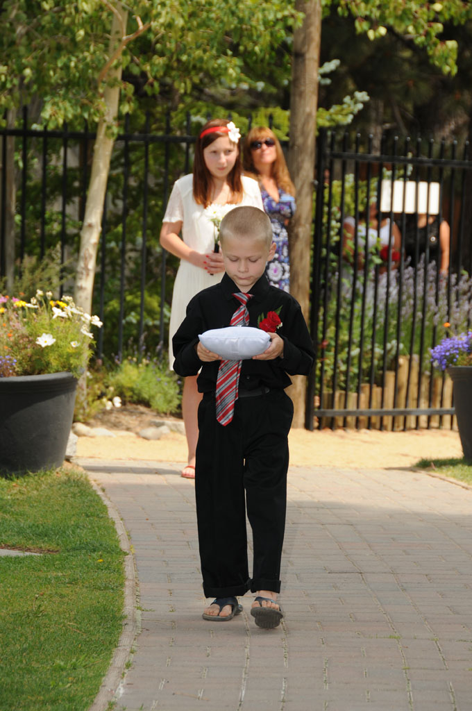 The ring bearer walking down the brick walkway.