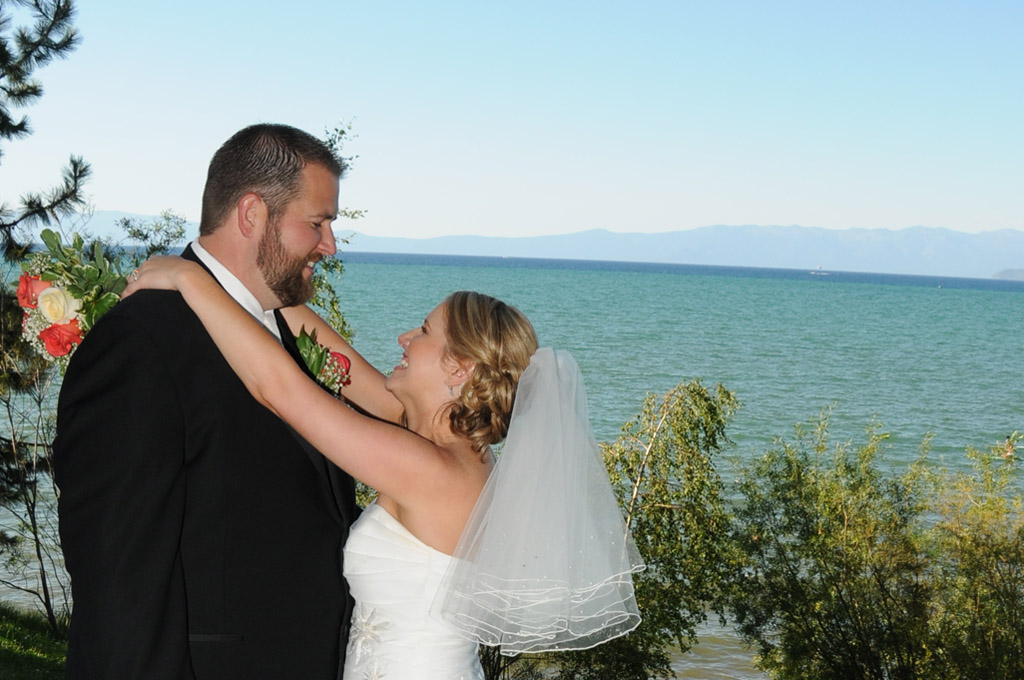 Bride wraps her arms around her groom and displaying a big smile.
