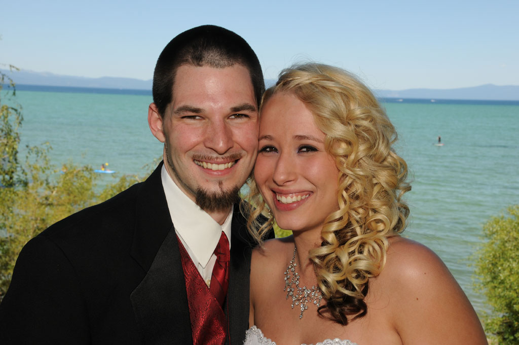 Smiling pair put their cheeks together.