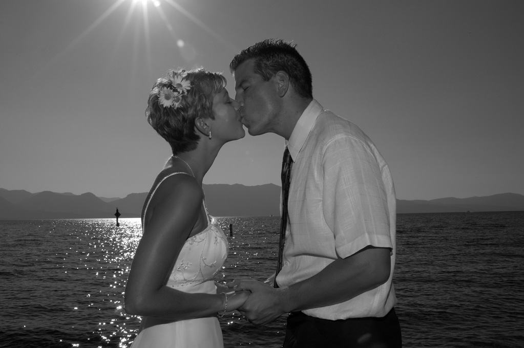 Silhouetted black and white image of couple kissing.