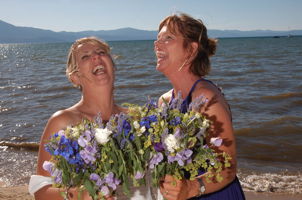 Happy bridesmaids laughing while holding beautiful bouquets.