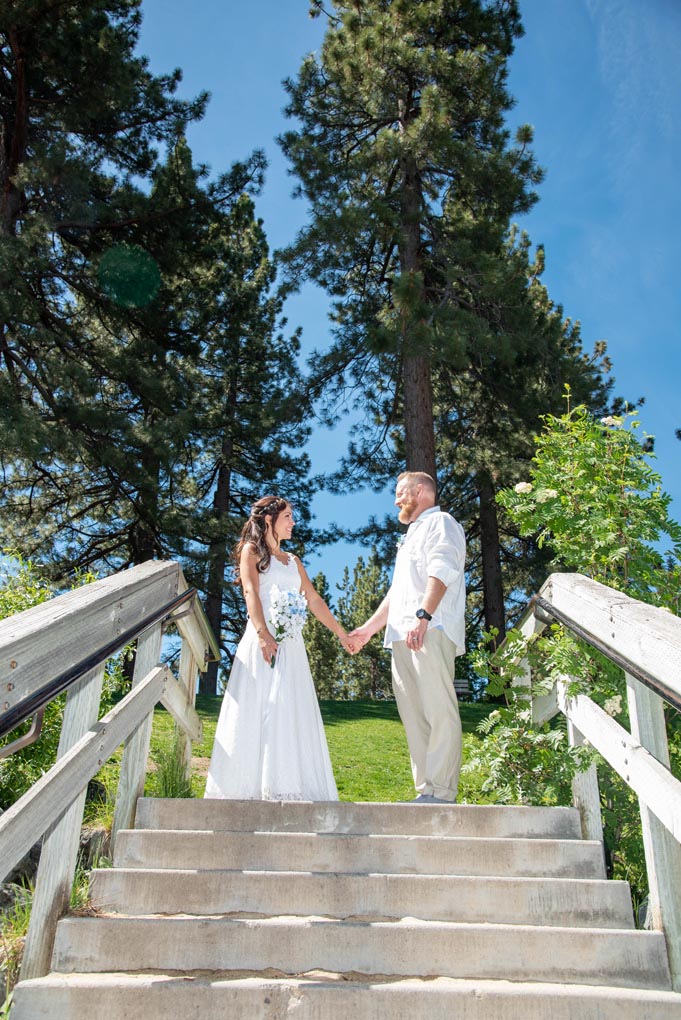 Just married couple standing at the top of the staircase.