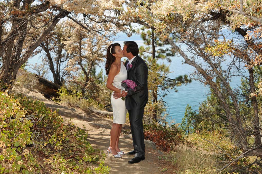 Newly wedded couple spend a romantic moment together under colorful trees.