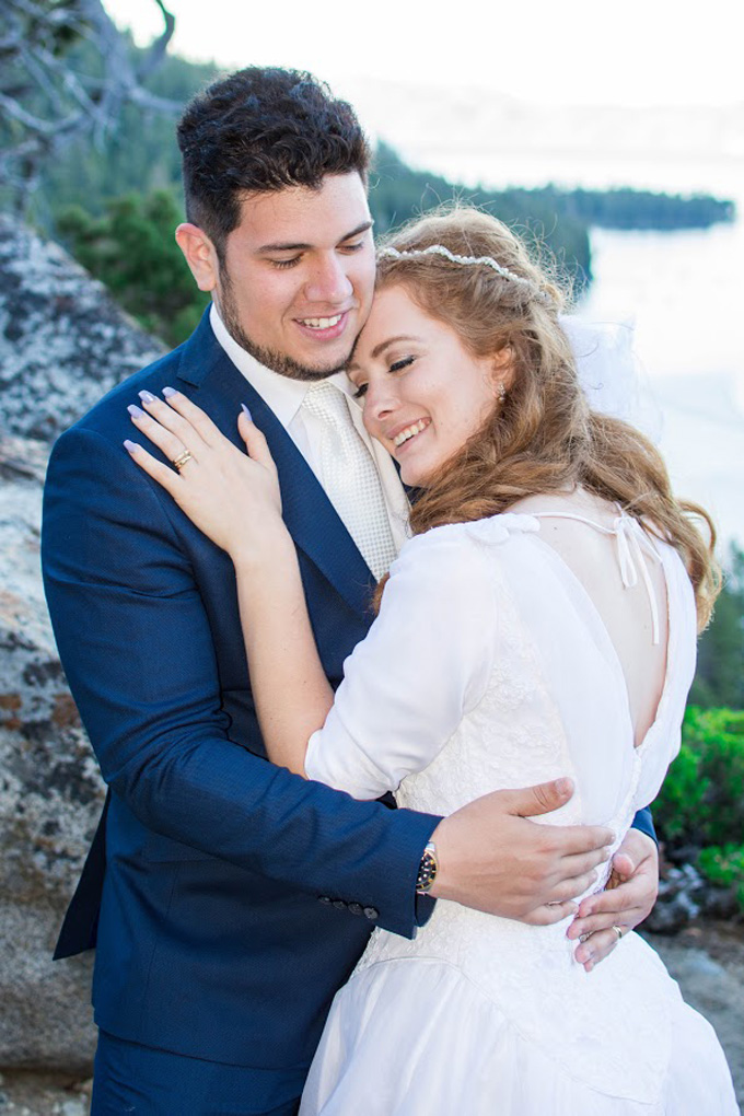 Newly wedded pair lovingly embrace.